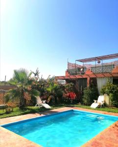 - une piscine en face d'une maison dans l'établissement Riad Darga Rouge, à Marrakech