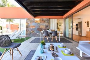 an open living room with a table and chairs at Par 4 Blue Star by VillaGranCanaria in La Playa de Arguineguín