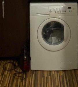 a washing machine sitting on the floor with a phone at TALINA Apartament in Oradea