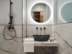 a bathroom with a sink and a mirror at Athens City View Urban Suites in Athens