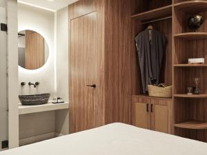 ein Schlafzimmer mit einem Holzschrank und einem Bademantel. in der Unterkunft Athens City View Urban Suites in Athen