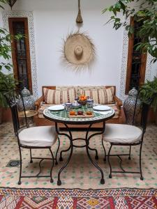 sala de estar con mesa y 2 sillas en Riad Smara, en Marrakech