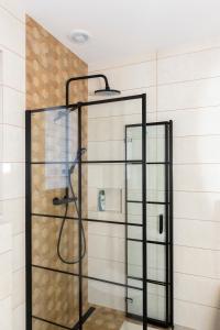 una ducha con puerta de cristal en un baño en Słoneczna Chałupka, en Zawoja
