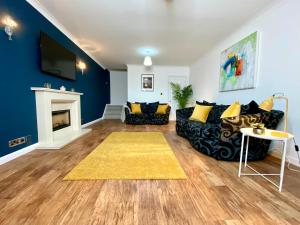 a living room with a couch and a fireplace at Lovely house in a great location with Parking, WiFi & Smart TV - Near Poole & Bournemouth in Poole