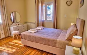 sypialnia z łóżkiem, lustrem i komodą w obiekcie Villa Christine Afionas Corfu w mieście Afionas