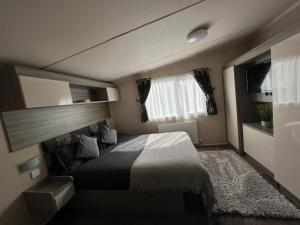 a bedroom with a large bed and a mirror at Forest lodge in Sway