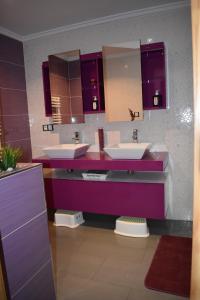 a purple bathroom with two sinks and mirrors at Dinoapartamento in Teruel +6 photos