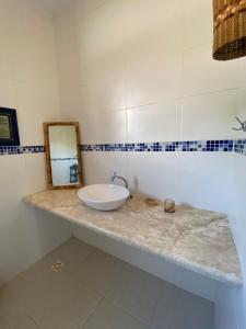 a bathroom with a sink and a mirror on a counter at Casa Flamboaiã, Aluguel de Temporada, BA. 2022/23 in Guaibim