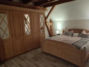 ein Schlafzimmer mit einem Holzbett und einem großen Schrank in der Unterkunft Sonnige Zimmer in Eberhardzell