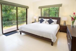 um quarto com uma cama grande e janelas grandes em Villa Mariposa - Peaceful and relaxing with ocean view & WiFi em San Antonio
