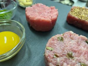 una mesa con carne y un huevo y un trozo de pan en Hotel Ristorante Scirocco, en Portopalo di Capo Passero