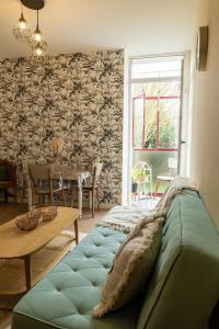 a couch sitting in a living room with a table at Au cœur des Remparts de Guérande: logement pour 4 in Guérande