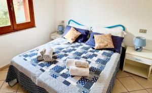 a blue and white bed with towels on it at Casa Greta in Costa Rei