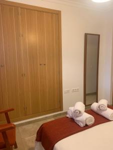um quarto com duas toalhas numa cama e um espelho em Casa Vigon em Sanlúcar de Barrameda