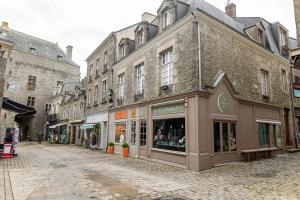 eine Straße in einer Stadt mit Gebäuden und Geschäften in der Unterkunft Au cœur des Remparts de Guérande: logement pour 4 in Guérande