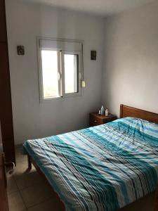 1 dormitorio con cama y ventana en Вила Маламос en Paralía Avdhíron