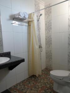 a bathroom with a shower with a toilet and a sink at Antari Hotel Pemuteran in Pemuteran