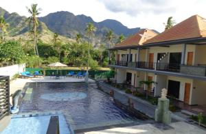 a house with a swimming pool next to a resort at Antari Hotel Pemuteran in Pemuteran
