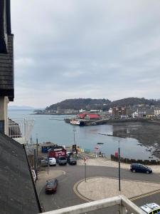 a view of a harbor with cars parked next to the water at Station View in Oban