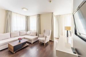 a living room with a white couch and a chair at 3L Apartments Diva in Kołobrzeg