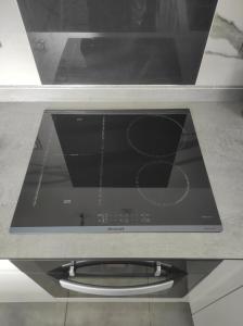 un forno a microonde seduto sopra un piano cottura di Gray Coconut Sorbet, T3 tout équipé avec parking gratuit a Le Moule