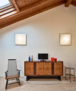 a living room with a tv and a chair at Al Canton Agriturismo di Design in San Michele al Tagliamento