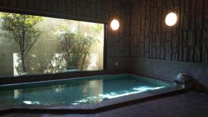 a large swimming pool with a window in a room at Hotel Route-Inn Court Azumino Toyoshina Ekiminami in Azumino