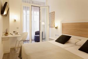a bedroom with a bed and a desk and a chair at Hotel Santa Rosa, Blue Hoteles in Gijón