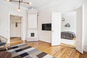 een witte woonkamer met een open haard en een televisie bij Elegant and light 3 room apartment in SoFo 97sqm in Stockholm
