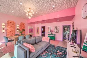 塔爾薩的住宿－Unique, Themed Tulsa Escape about 2 Mi to Downtown!，粉红色的客厅配有沙发和桌子