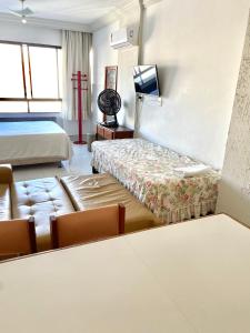 a hotel room with a couch and a bed at Flat Vista Mar Frente ou Lateral na Barra em Salvador in Salvador