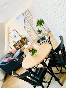 a table and chairs in a living room with a staircase at Dwupiętrowy apartament rodzinny w centrum miasta z darmowym parkingiem Pod Złotym Lwem V in Kłodzko