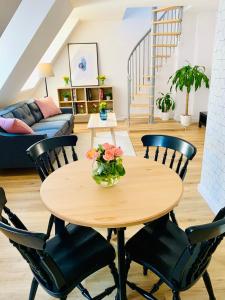 uma sala de estar com uma mesa de madeira e cadeiras em Dwupiętrowy apartament rodzinny w centrum miasta z darmowym parkingiem Pod Złotym Lwem V em Klodzko