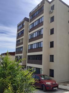 a red car parked in front of a building at Apartament Matei in Tulcea