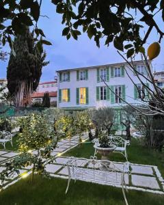 un jardín con bancos blancos y un edificio en Magnifique appartement sur jardin - Vieil Antibes, en Antibes