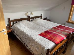 een slaapkamer met een bed met een deken erop bij Tallgatan Fjällbacka in Fjällbacka