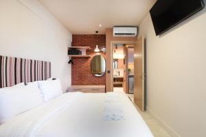 a bedroom with a white bed and a mirror at Pavo Art Hotel in Heraklio Town