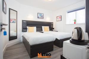 ein Schlafzimmer mit 2 Betten und einem TV in der Unterkunft Heathrow Windsor Apart Hotel in Slough