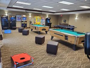 a gaming room with two pool tables and arcade machines at Comfort Suites in Oshkosh