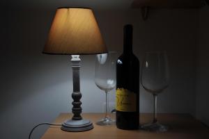 eine Flasche Wein und zwei Gläser auf dem Tisch in der Unterkunft Apartman Bojanic in Podgorica