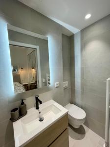 y baño con lavabo, aseo y espejo. en Magnifique appartement sur jardin - Vieil Antibes, en Antibes