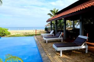 a villa with a swimming pool next to the beach at Wellé Wadiya Beach Villa in Kalpitiya