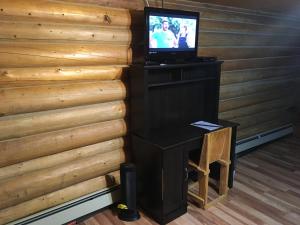 a desk with a television on top of a wooden wall at Double G Service in Muncho Lake