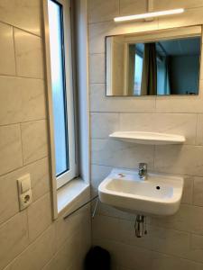 a bathroom with a sink and a mirror at Strandappartement De Ark in Zoutelande