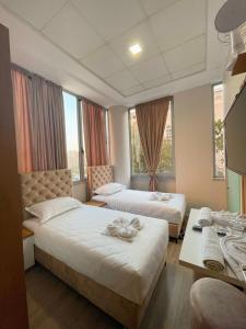 2 camas en una habitación de hotel con ventanas en Hotel Princ, en Shkodër