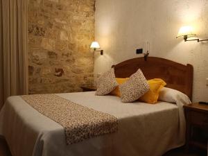 Un dormitorio con una cama con almohadas. en hostal Decerca Prádena, en Prádena