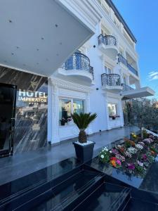 ein Hotel mit Blumen vor einem Gebäude in der Unterkunft Imperator Hotel in Tirana