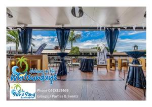 a deck with tables and chairs on a boat at Airlie Sun & Sand Accommodation Studio #1 in Airlie Beach