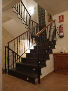 a staircase with black railings in a house at hostal Decerca Prádena in Prádena