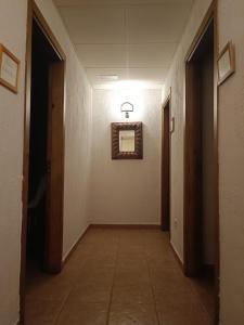 um corredor vazio com um espelho na parede em hostal Decerca Prádena em Prádena